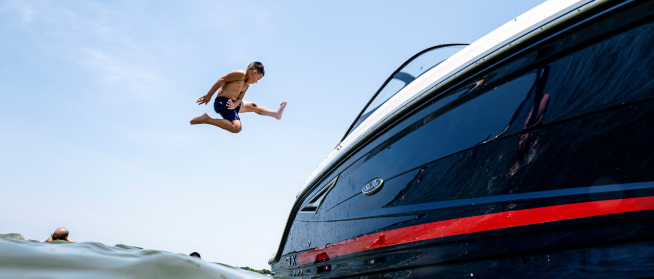 Boy jumping off boat into water